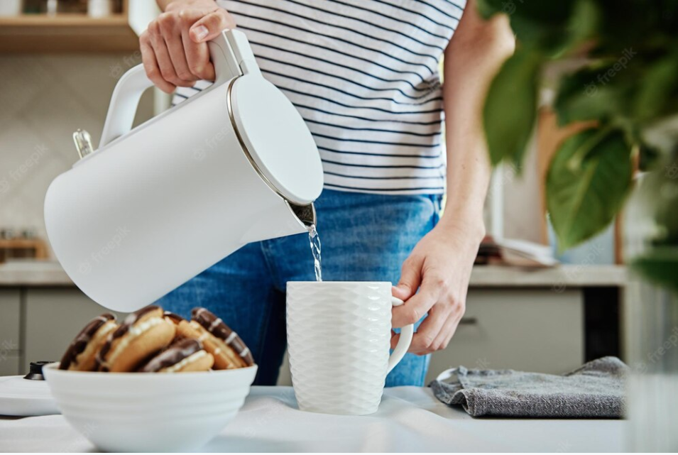 Woman in striped shirt pouting tea from a kettle