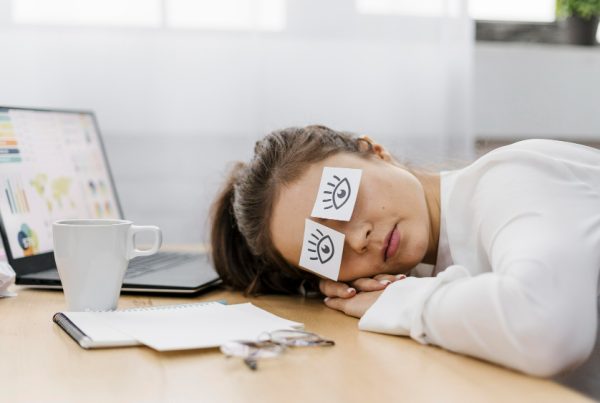 tired-businesswoman-covering-her-eyes-with-drawn-eyes-paper