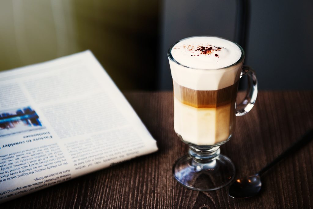 Coffee Shop Cafe Latte Cappuccino next to a Newspaper