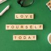 Love yourself today motivational message on green table