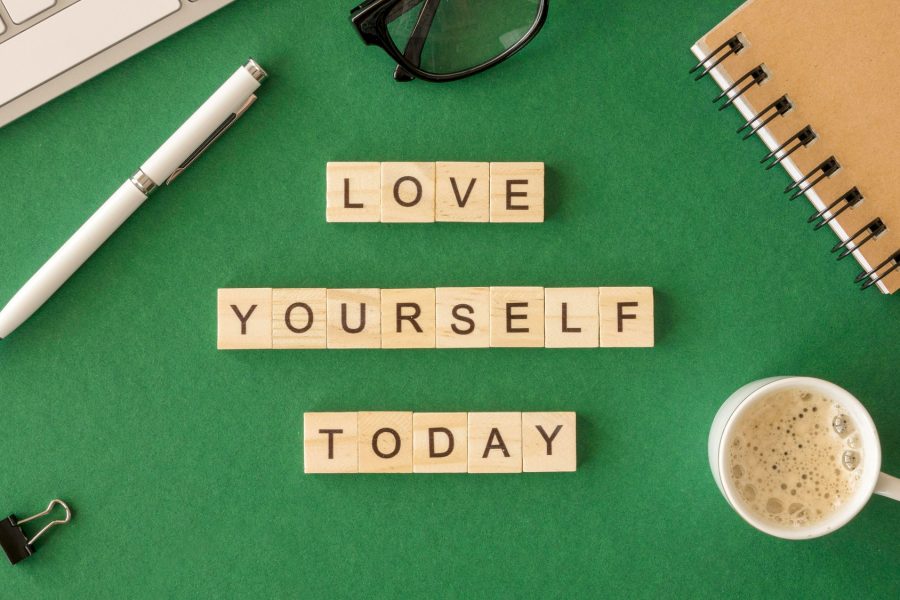 Love yourself today motivational message on green table