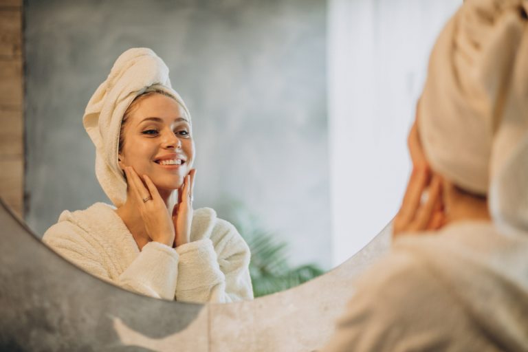 woman at home applying cream mask