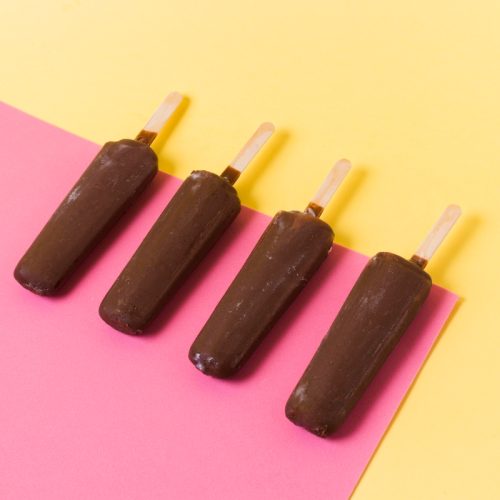 Chocolate popsicles on a pick and yellow background