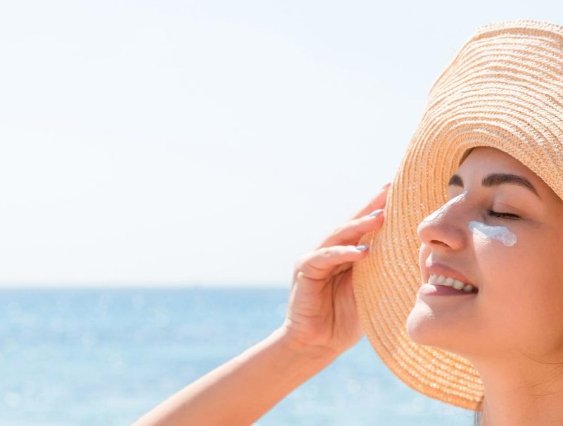 Smiling women in a sunhat at the beach