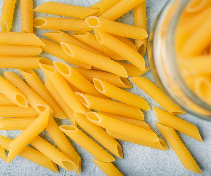 uncooked penne pasta on a table