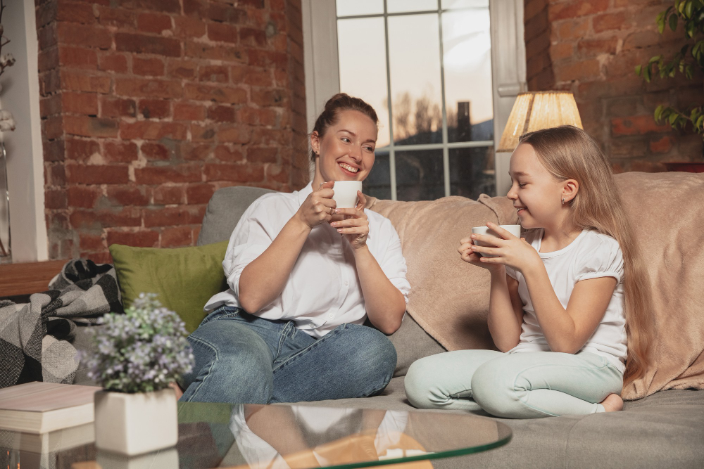 Mother and daughter sitting on a couch with tea
