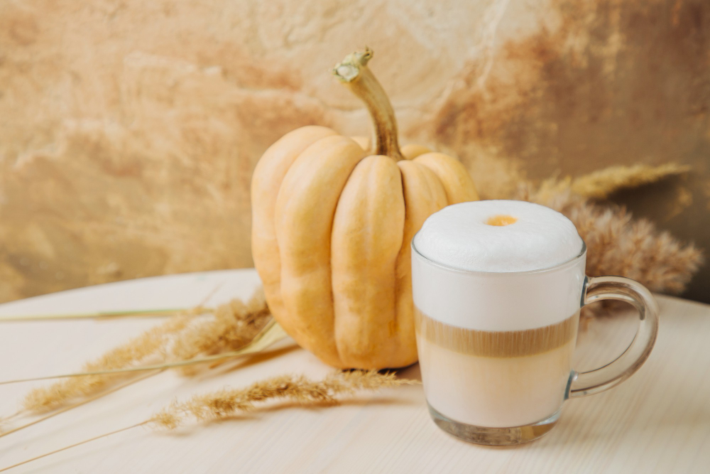 A pumpkin next to a pumpkin spice latte