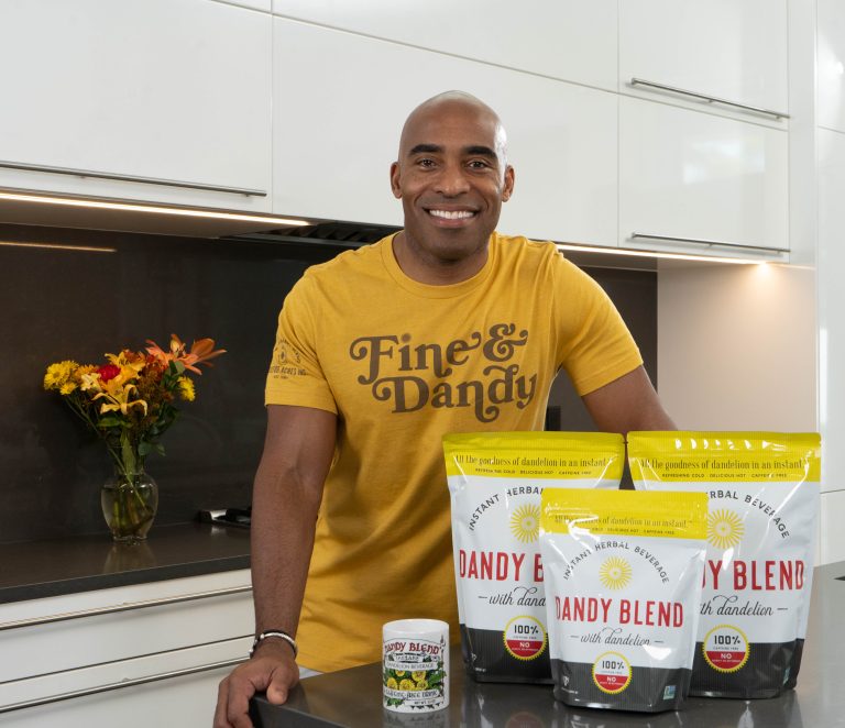 Tiki Barber with bags of Dandy Blend in kitchen