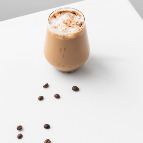 Latte in a glass cup on a white table