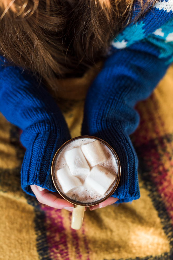 Lady holding mug with drink and marshmallows