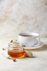 Coffee cup with jar of honey