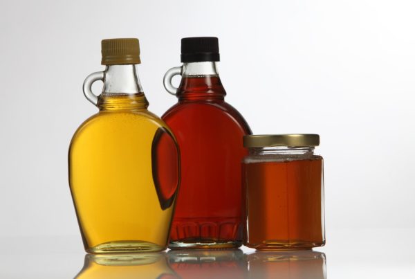 Clear glass jars with honey and maple syrup