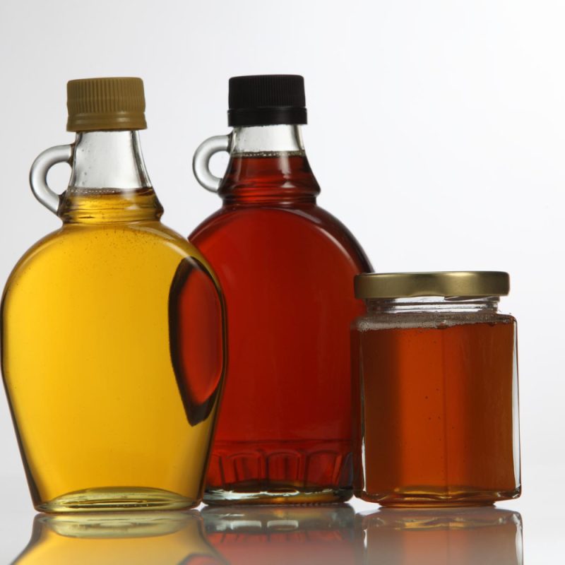 Clear glass jars with honey and maple syrup