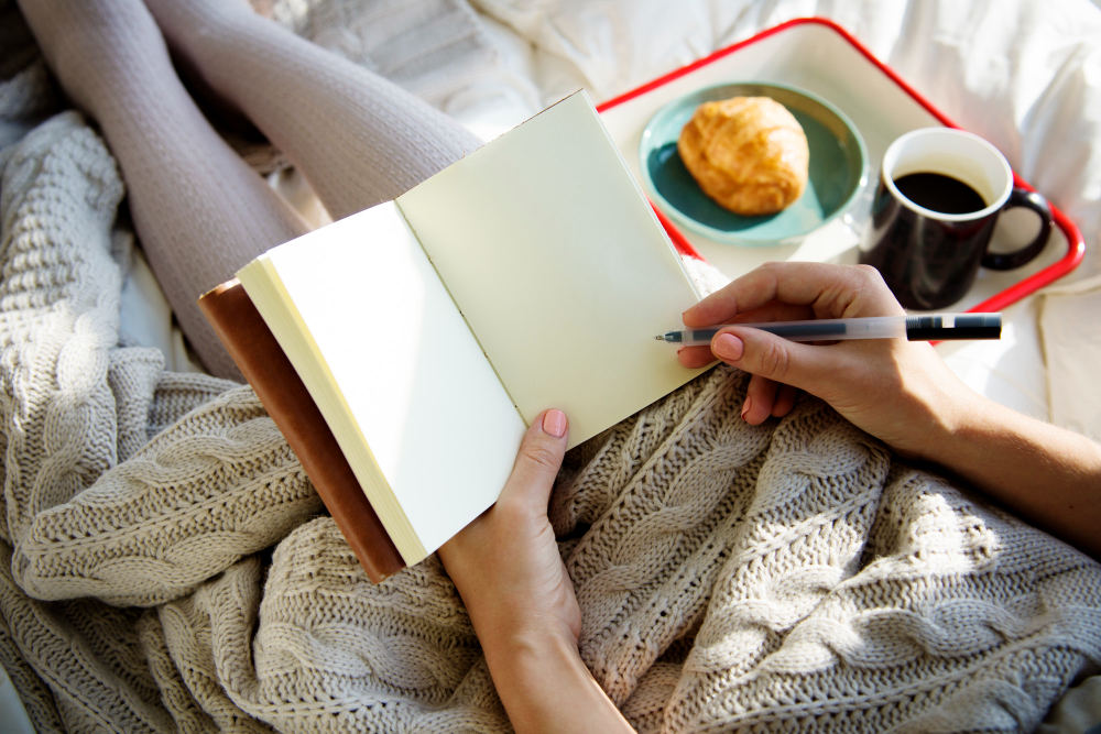 Woman with a journal in her bed