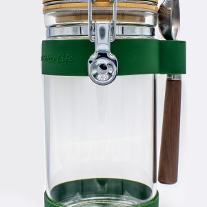 Glass canister with green on bands on the top and bottom. Includes a serving spoon