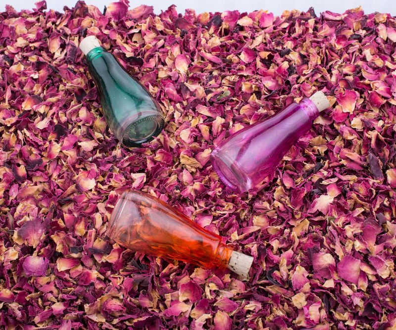 3 bottles of syrup on rose petals