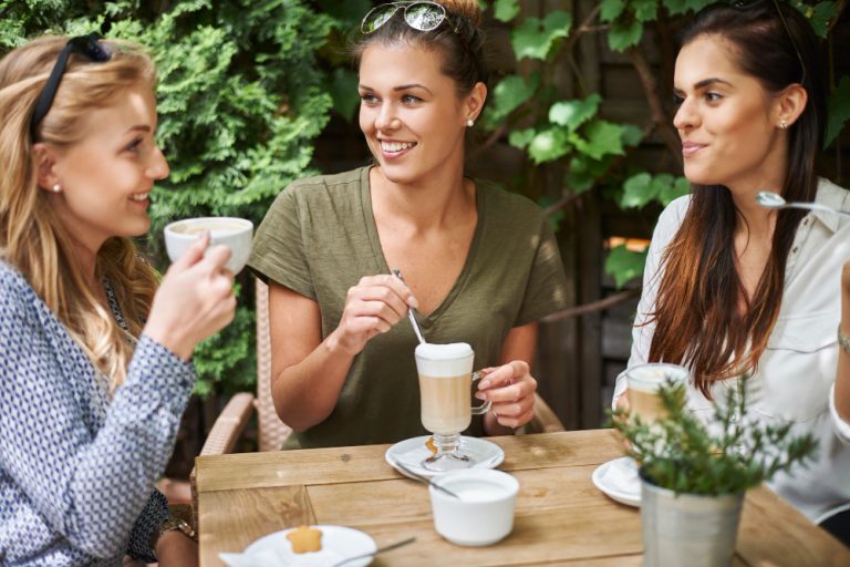 Women drinking coffee at an outside table