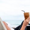 Woman with an iced drink by the ocean