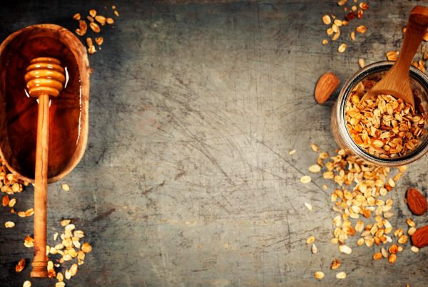 Top view of bowls of granola and honey