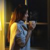 Woman drinking from a coffee cup in evening