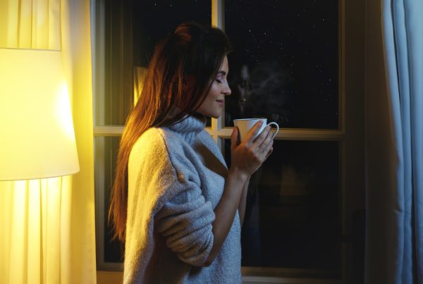 Woman drinking from a coffee cup in evening