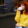 Woman in yellow sweater enjoying a cup of hot tea