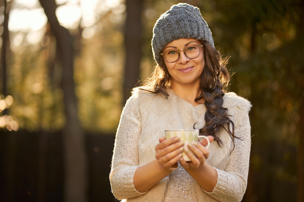 Woman drinking a hot cup of coffee in the fall