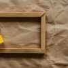 Blank photo frame with soft shadows and yellow scotch tape on craft cardboard paper background