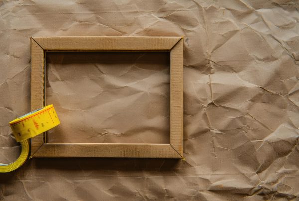 Blank photo frame with soft shadows and yellow scotch tape on craft cardboard paper background