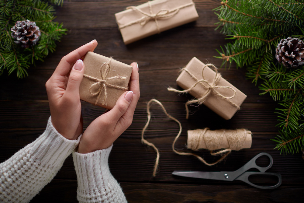 Hands holding a brown paper gift wrapped box