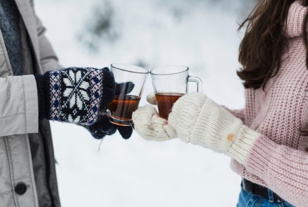 2 people outside with hot tea in clear glasses