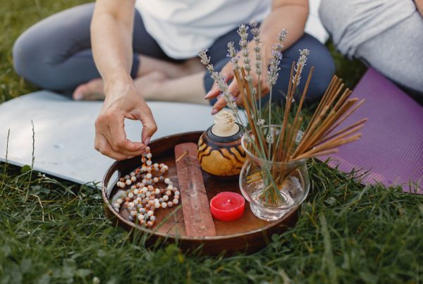 couple outside on yoga mats and meditation beads