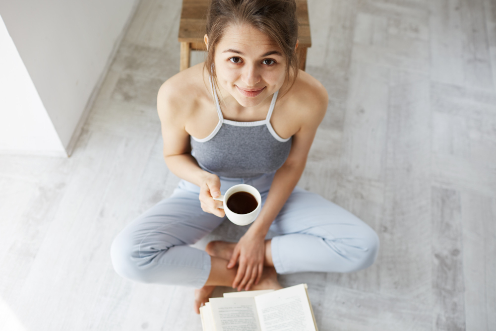 Woman sitting on the floor with coffee and a journal