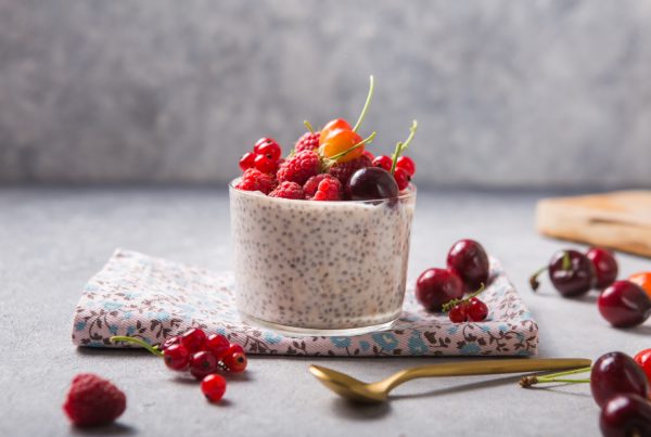 Glass on a table with chia seed pudding and fruit