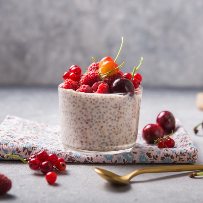 Glass on a table with chia seed pudding and fruit