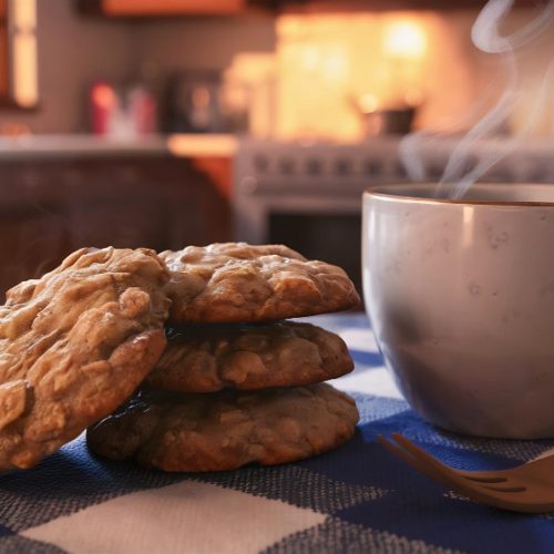 Cookies next to a steaming cup of tea