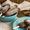 Fudgesicles on a teal plate on a wood table