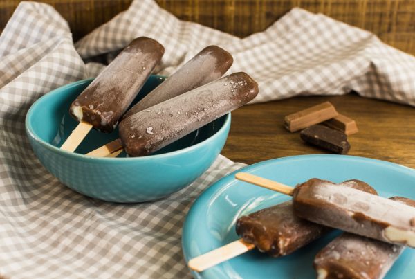 Fudgesicles on a teal plate on a wood table