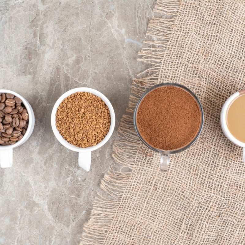 Cups with coffee beans and teas on a table