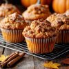Pumpkin spice muffins on a cooling rack on a wood table